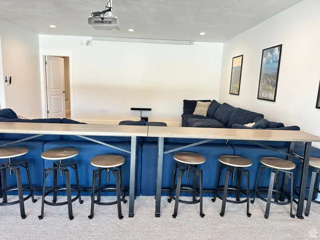 Bar area with a textured ceiling, light countertops, and recessed lighting