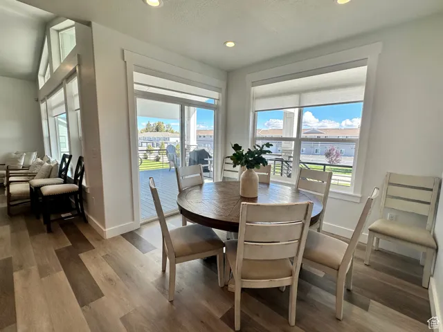 Dining room with wood finished floors, recessed lighting, and a textured ceiling