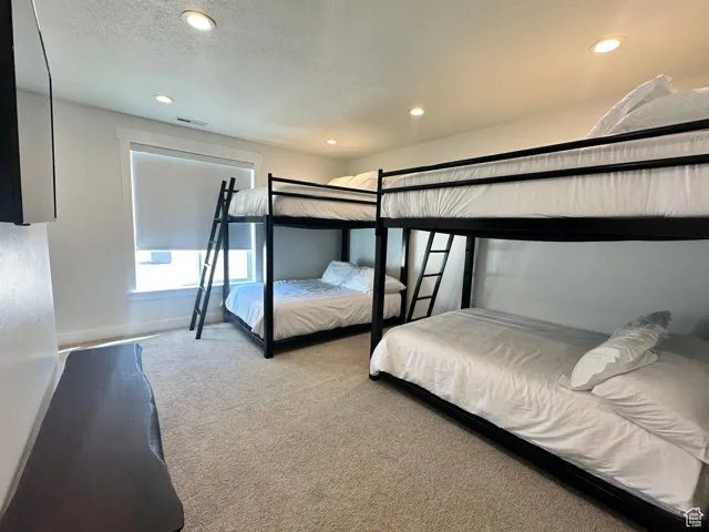 Bedroom with carpet flooring, a textured ceiling, and recessed lighting