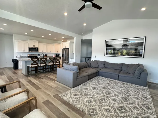 Living area with recessed lighting, light wood-style floors, vaulted ceiling, and a ceiling fan