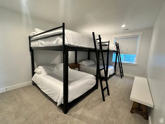 Bedroom with light colored carpet and recessed lighting