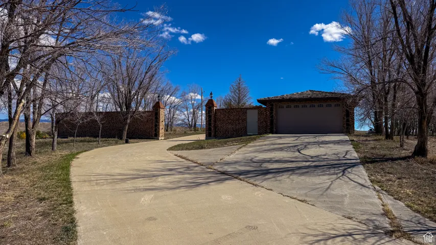 View of home's exterior featuring concrete driveway, a garage, and a chimney