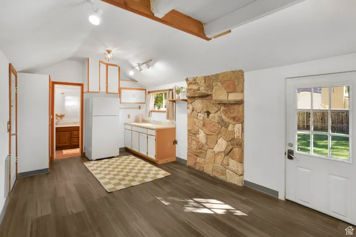 Kitchen featuring freestanding refrigerator, light countertops, dark wood-style floors, and track lighting