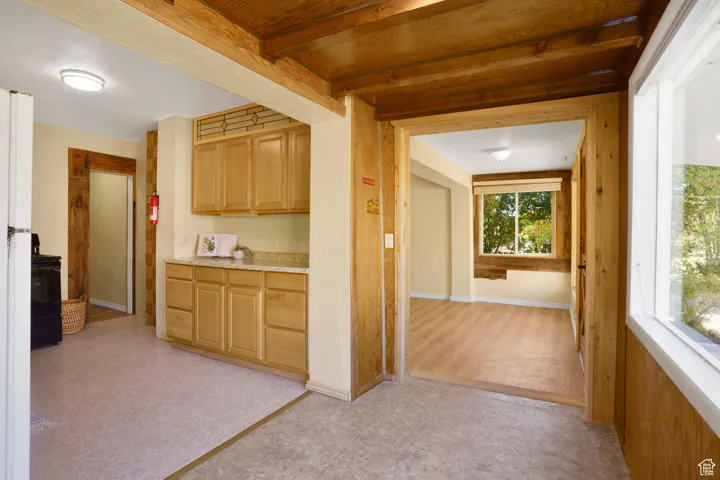Corridor with beam ceiling and light floors