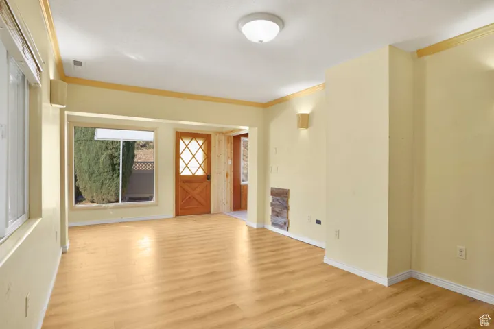 Entrance foyer featuring ornamental molding and light wood-style flooring