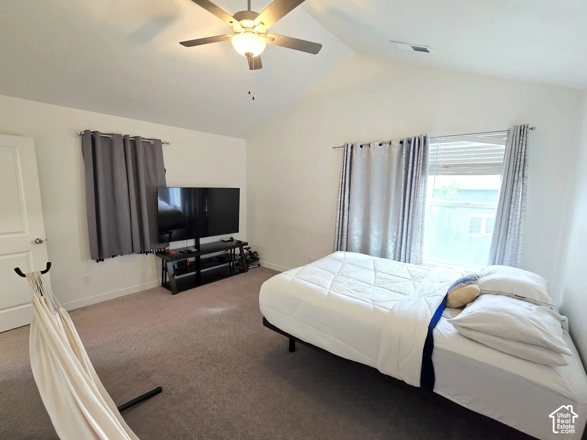 Carpeted bedroom with lofted ceiling and ceiling fan