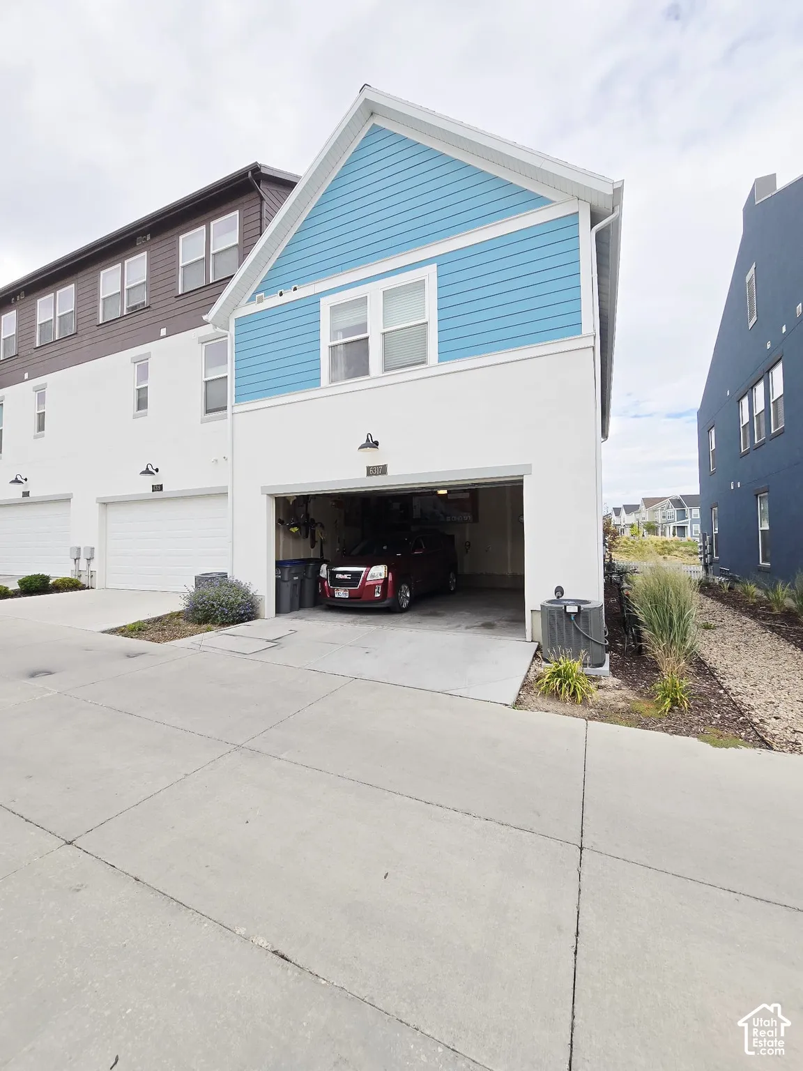View of front of house with concrete driveway and a garage