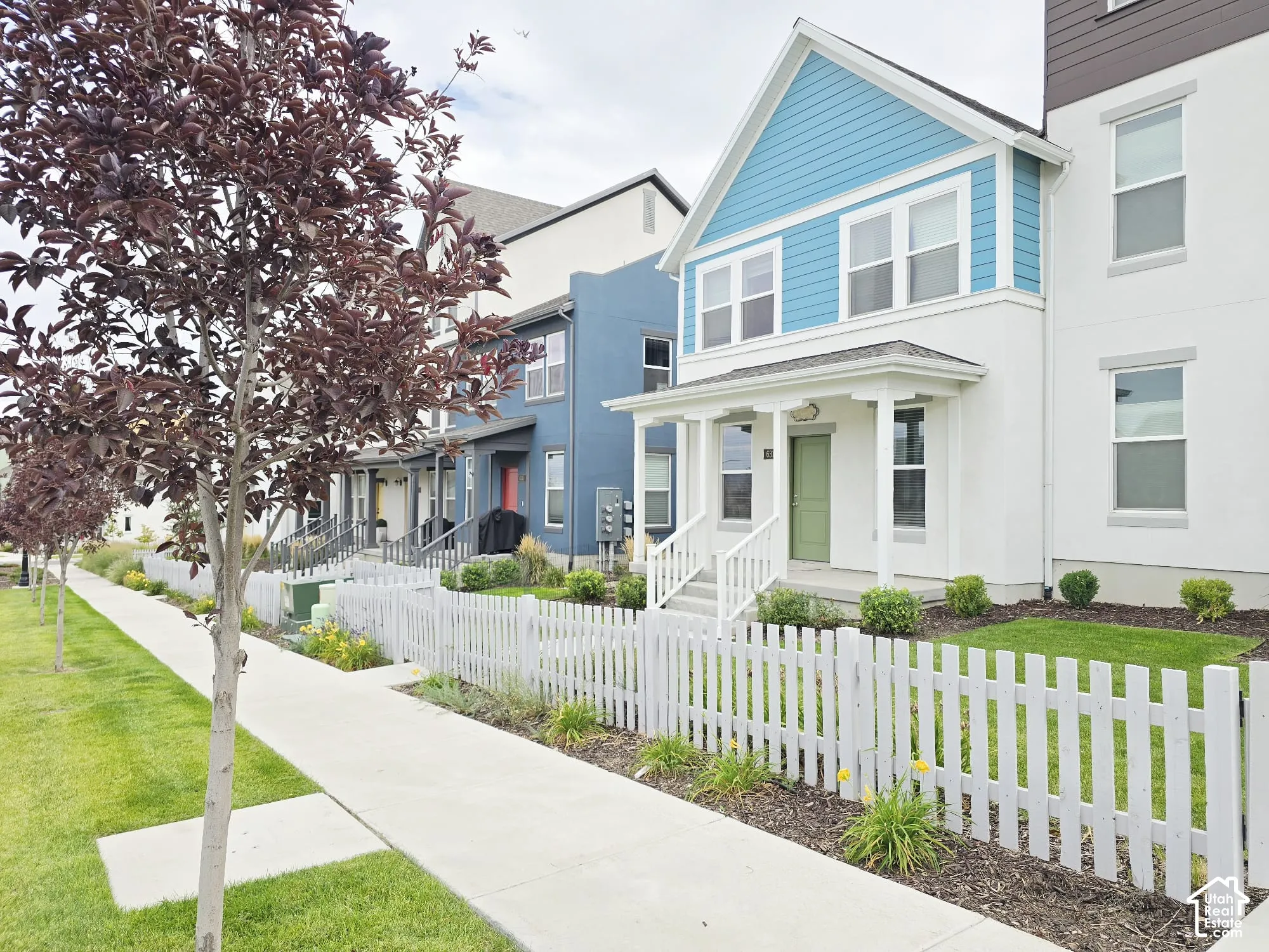 View of front of home featuring a fenced front yard, stucco siding, covered porch, and a residential view