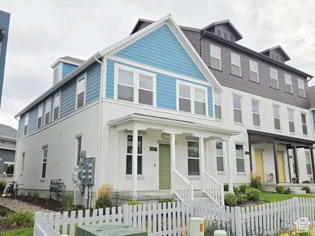 View of front of home with a fenced front yard, a porch, and stucco siding