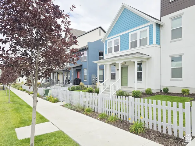 View of front of home featuring a fenced front yard, stucco siding, covered porch, and a residential view
