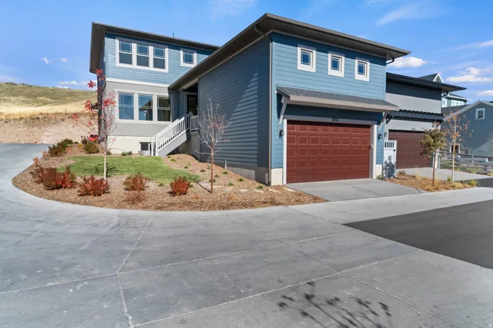 View of front of property featuring a garage and concrete driveway