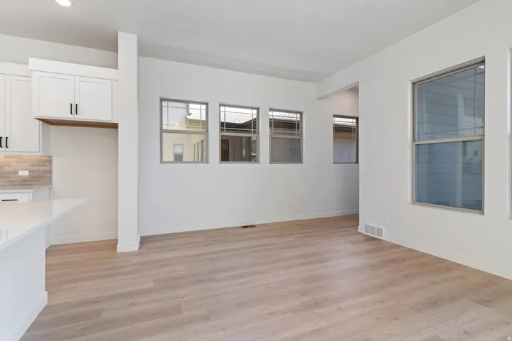Unfurnished dining area featuring light wood-type flooring and baseboards
