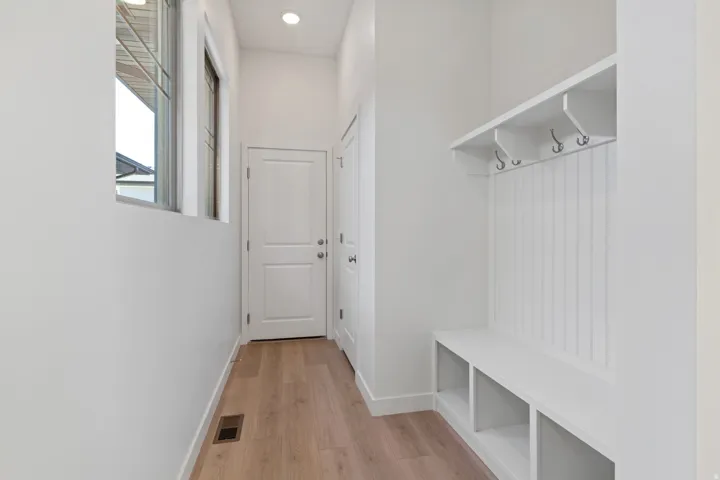 Mudroom with light wood finished floors and recessed lighting