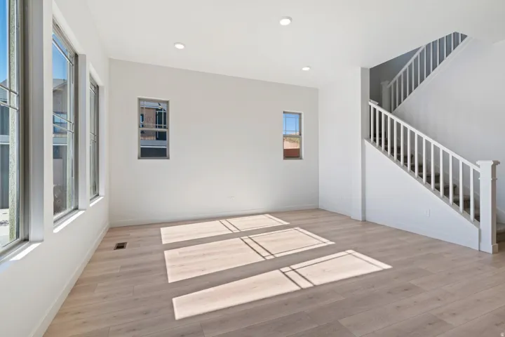 Unfurnished room with light wood-type flooring, recessed lighting, and stairway