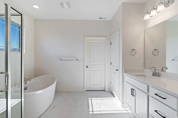 Full bathroom with a soaking tub, vanity, light marble finish floors, and a shower stall
