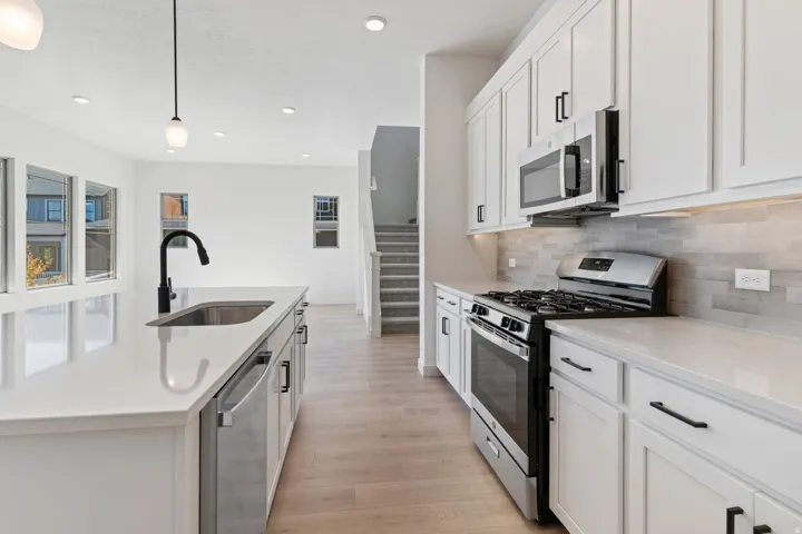Kitchen with stainless steel appliances, white cabinets, pendant lighting, recessed lighting, and light wood-style flooring