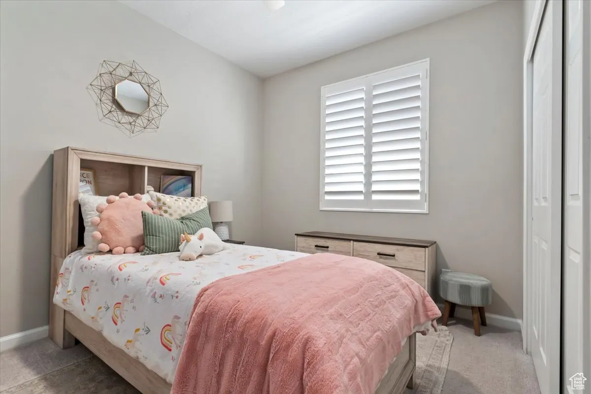 Bedroom with a closet and light colored carpet