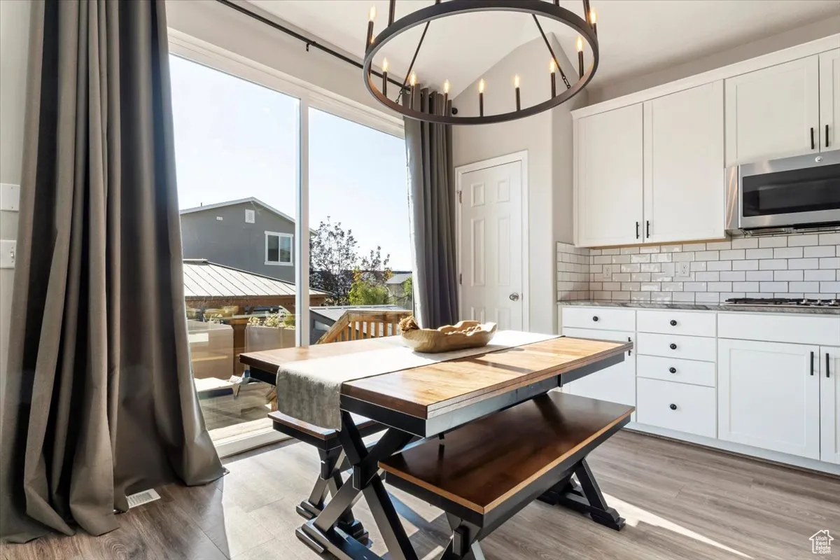Dining room with light wood-style floors and a chandelier
