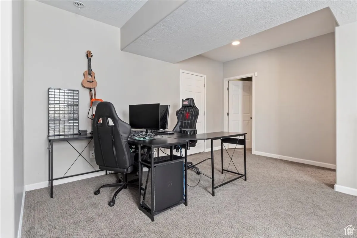 Home office with light carpet, a textured ceiling, and recessed lighting