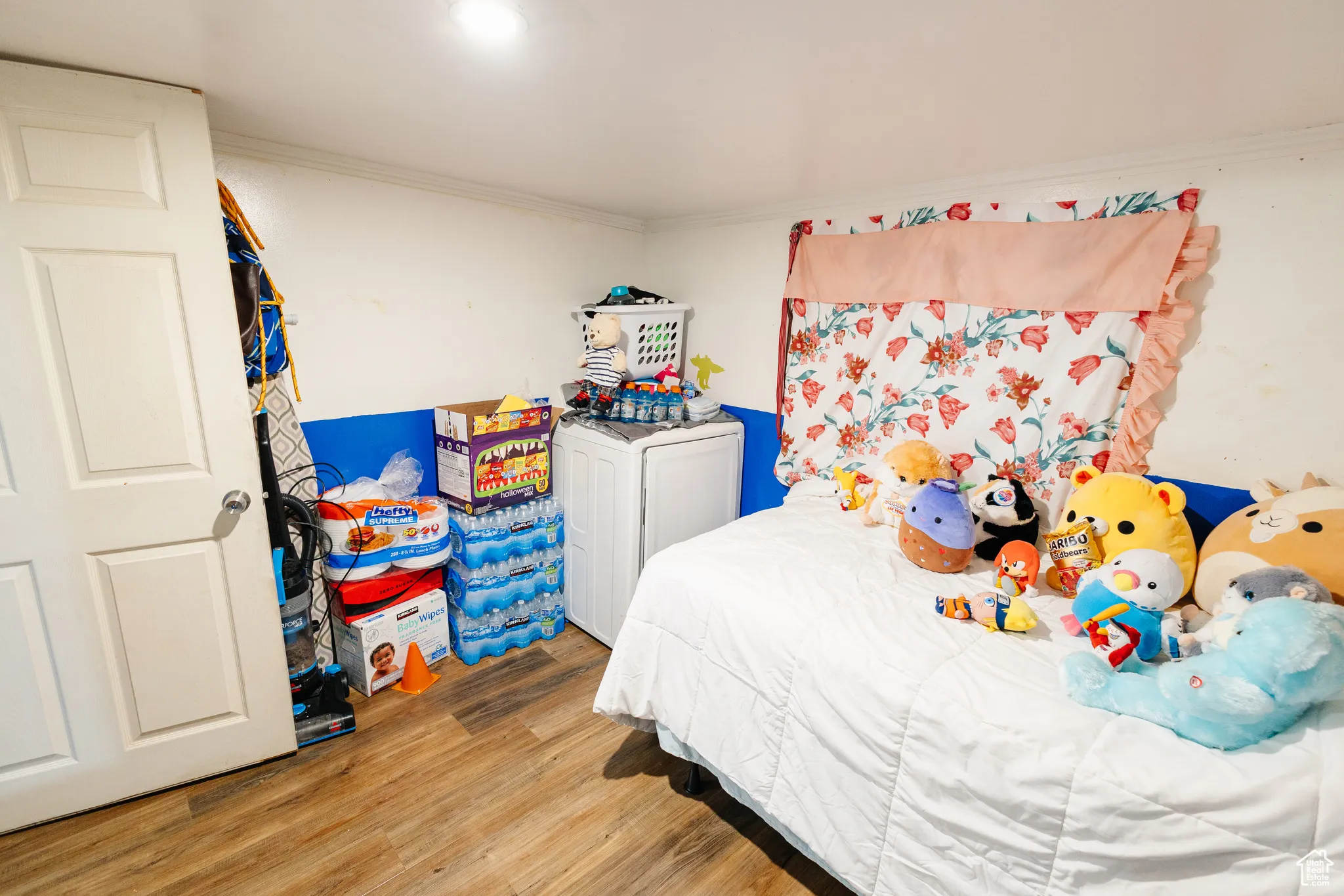 Bedroom with light wood-type flooring and crown molding