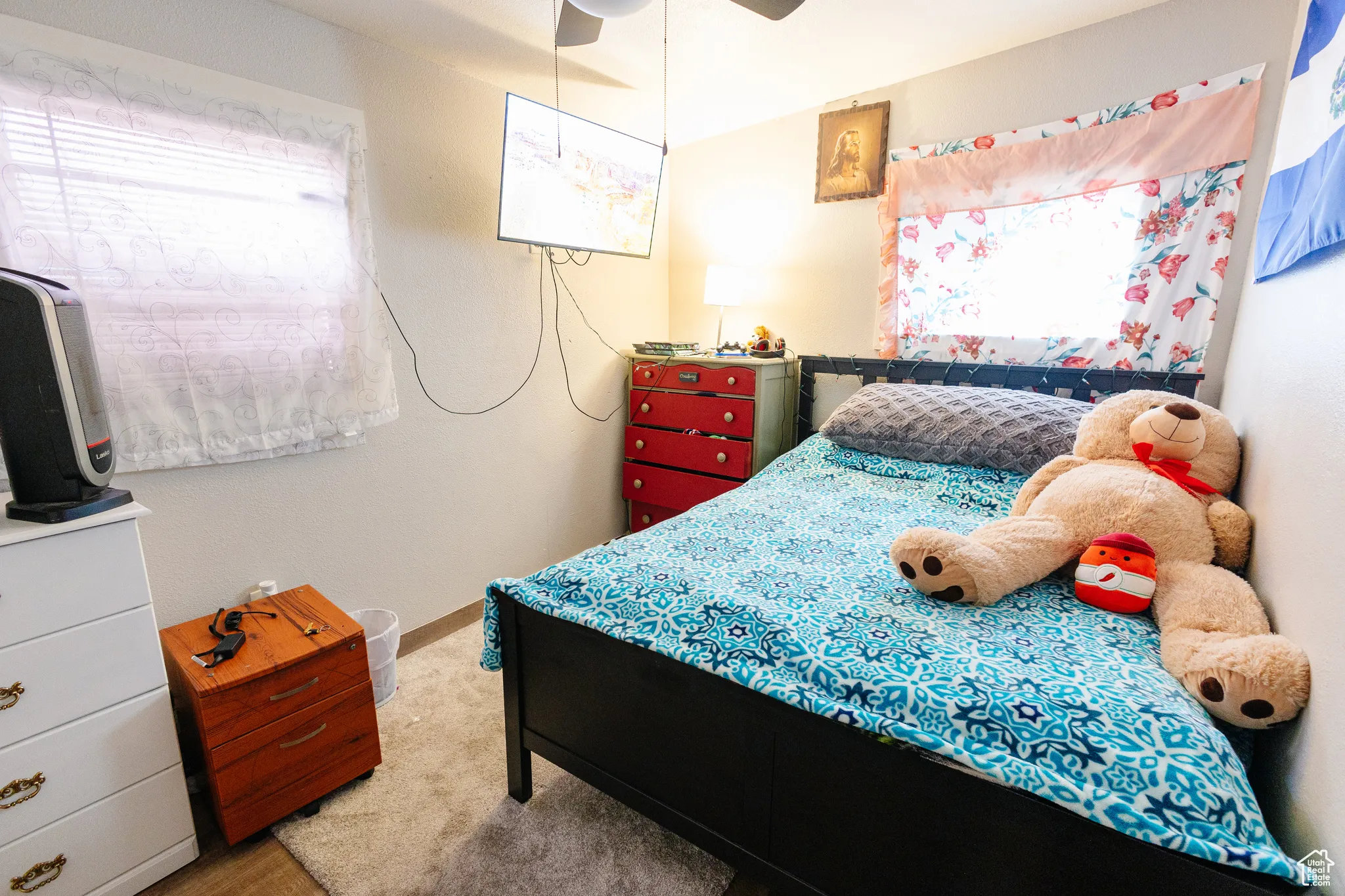 Bedroom featuring ceiling fan, multiple windows, and carpet