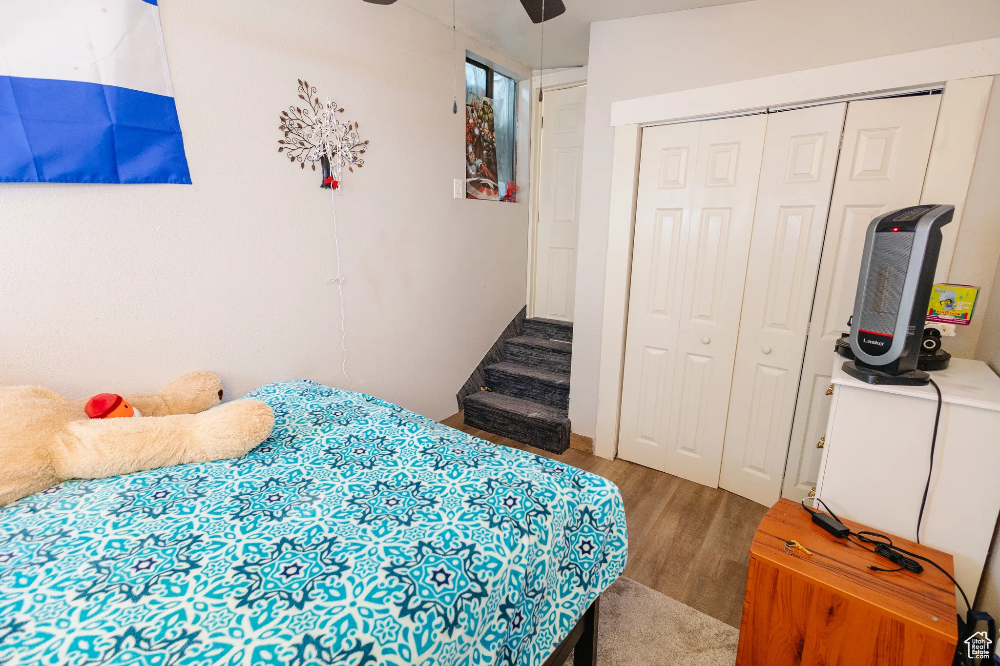 Bedroom with a closet, wood finished floors, and a ceiling fan
