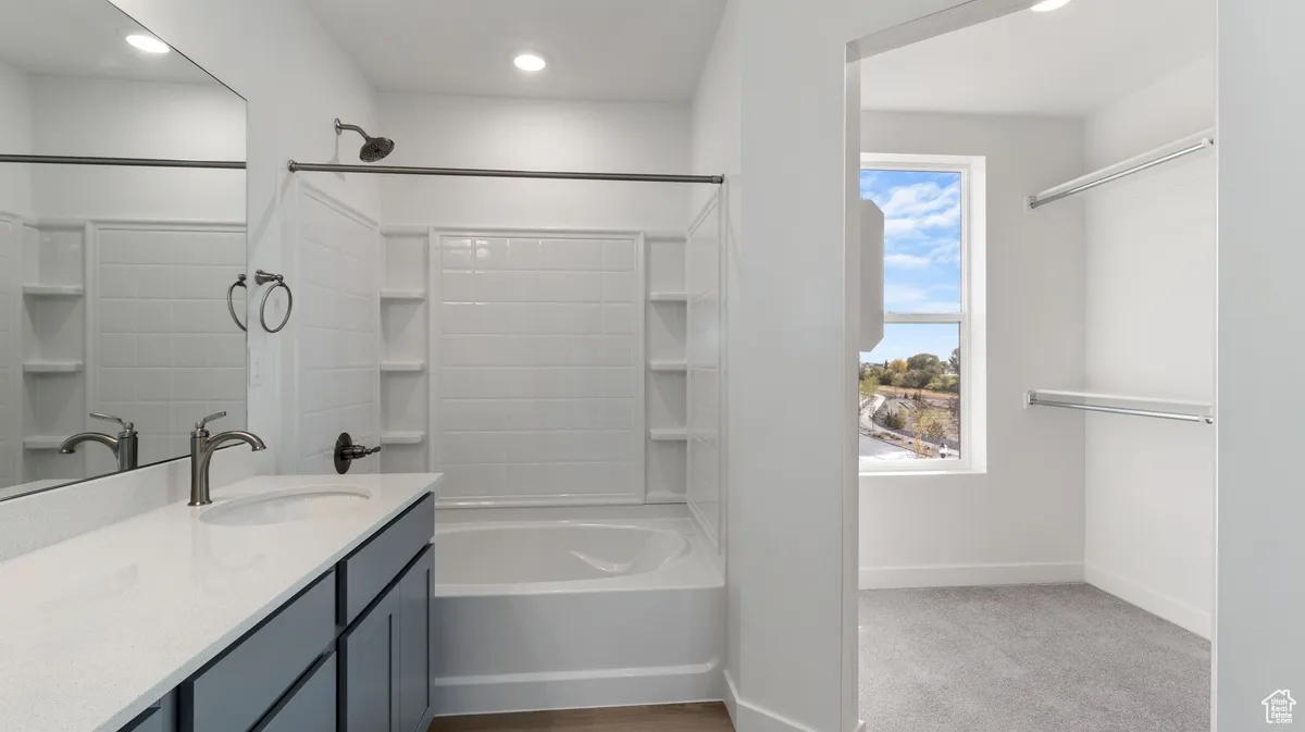 Bathroom featuring shower / bathtub combination, vanity, recessed lighting, and light colored carpet