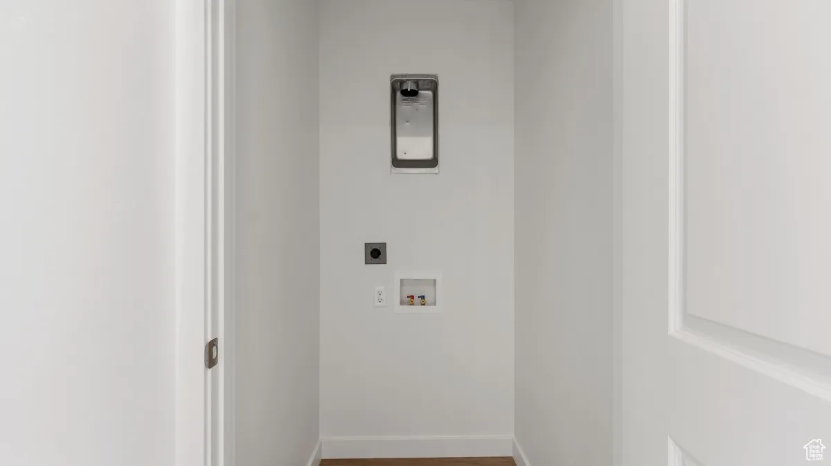 Laundry room featuring wood finished floors, hookup for an electric dryer, and washer hookup