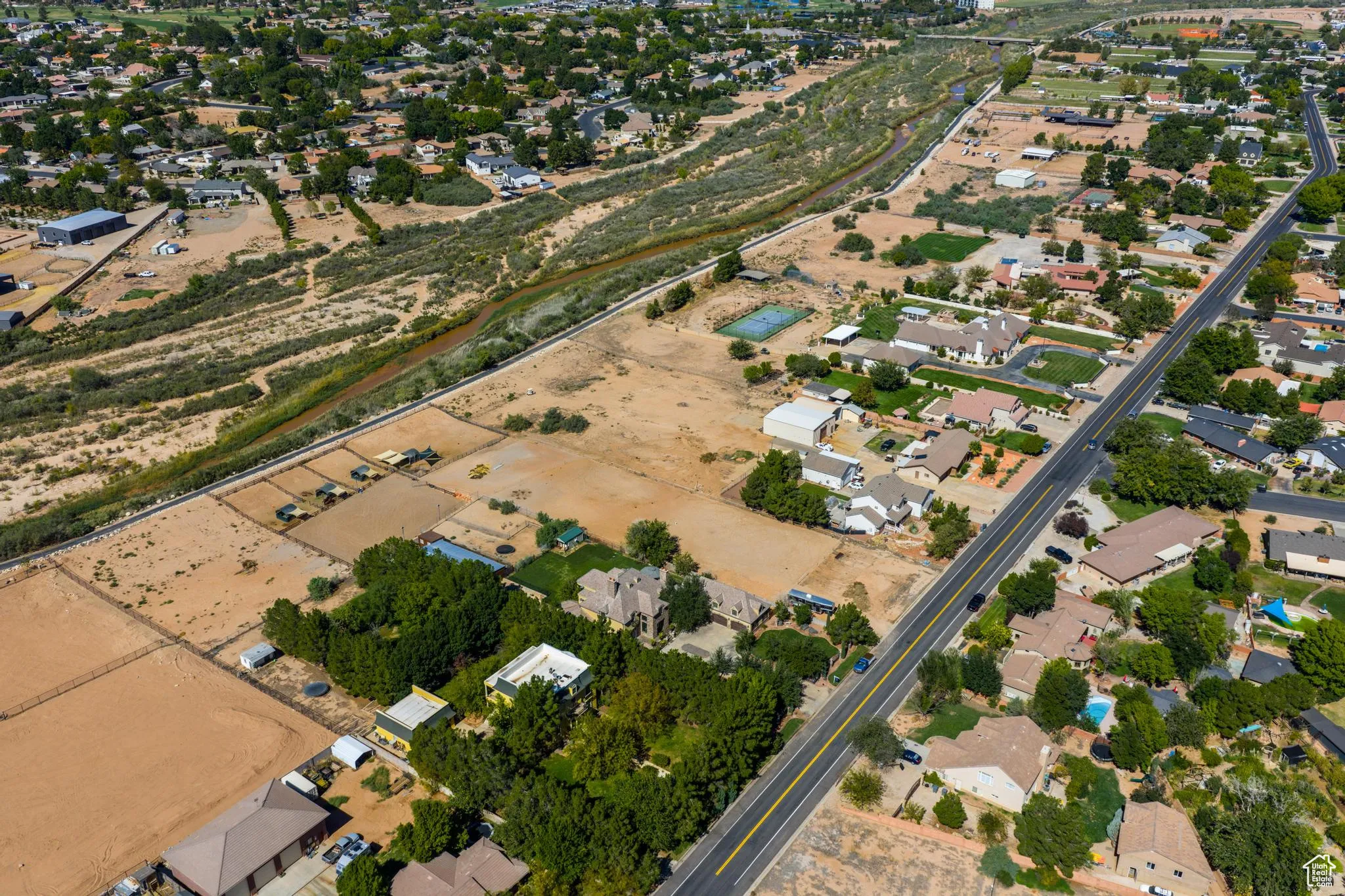 Aerial view of property and surrounding area with nearby suburban area