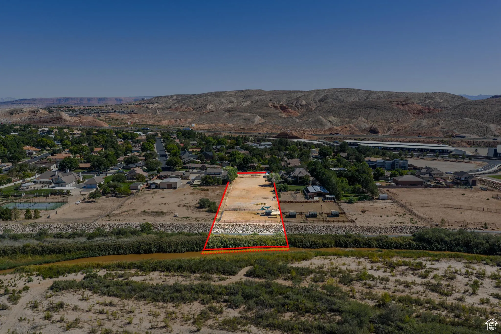 Aerial view of property's location with property parcel outlined and a mountainous background