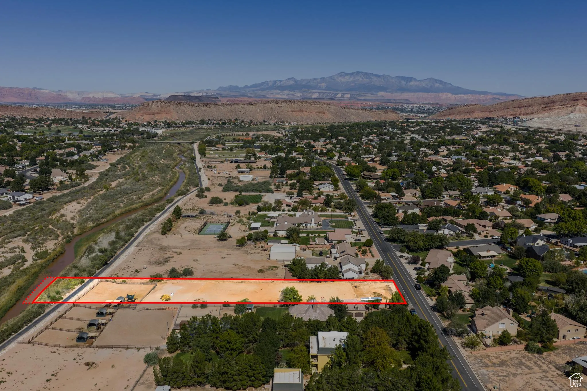 Aerial overview of property's location with a mountain backdrop and property boundaries highlighted