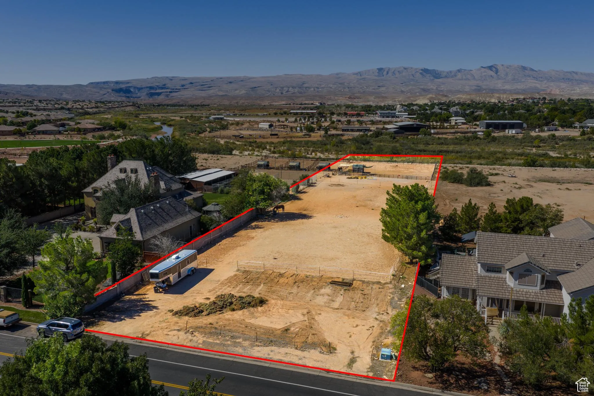 Aerial view of property's location with property parcel outlined and a mountainous background