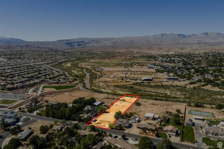 Aerial view of residential area featuring property parcel outlined and a mountainous background