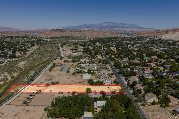 Aerial overview of property's location with a mountain backdrop and property boundaries highlighted