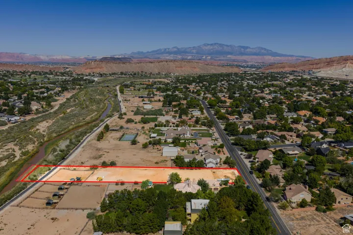 Aerial view of property and surrounding area featuring a mountainous background and property parcel outlined