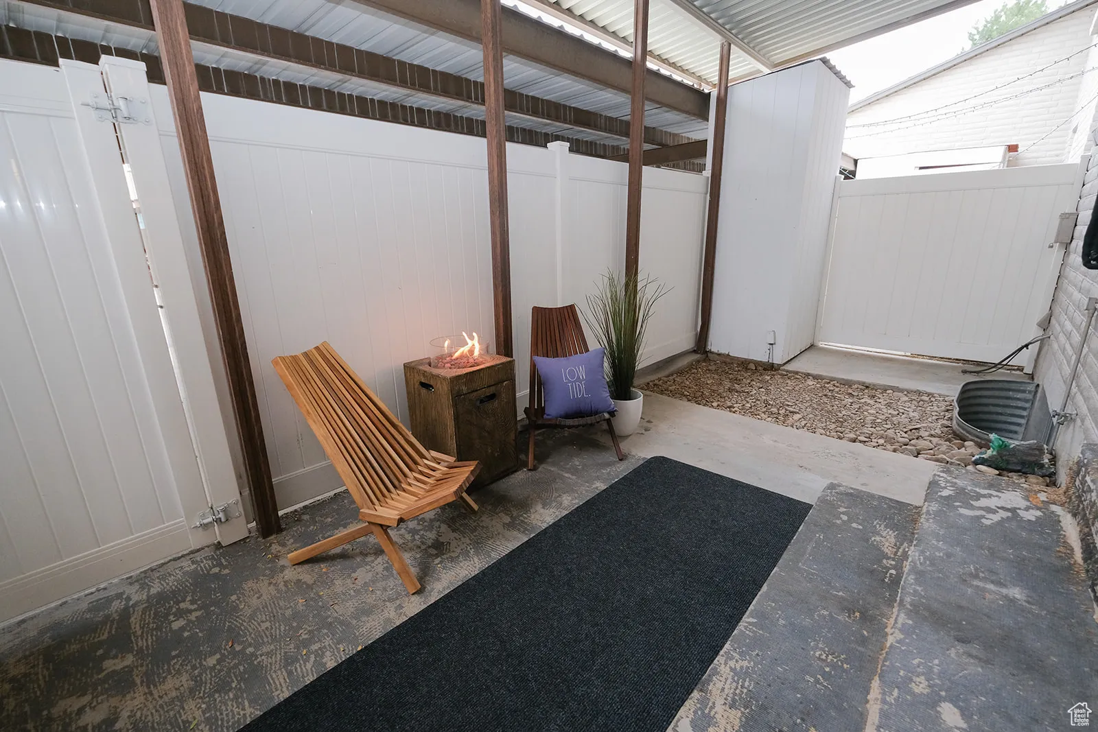 View of patio / terrace with a fire pit and entry to covered carport, 2 spaces for home owner. Unlimited guest parking out front.