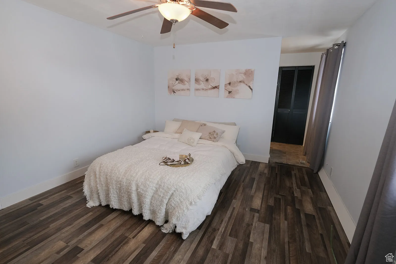 Primary bedroom with laminate flooring and ceiling fan.