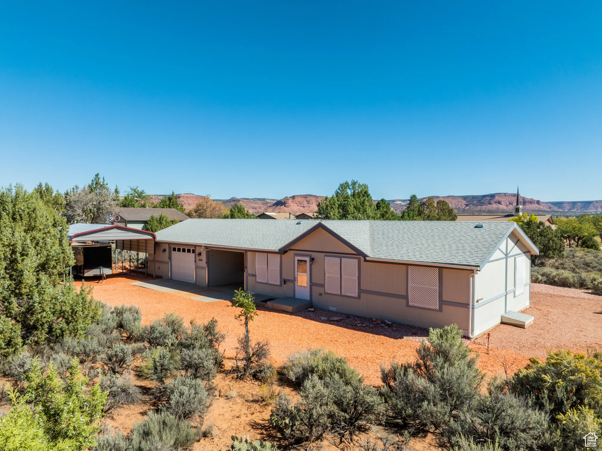 Ranch-style home with a shingled roof, a mountain view, driveway, and a garage