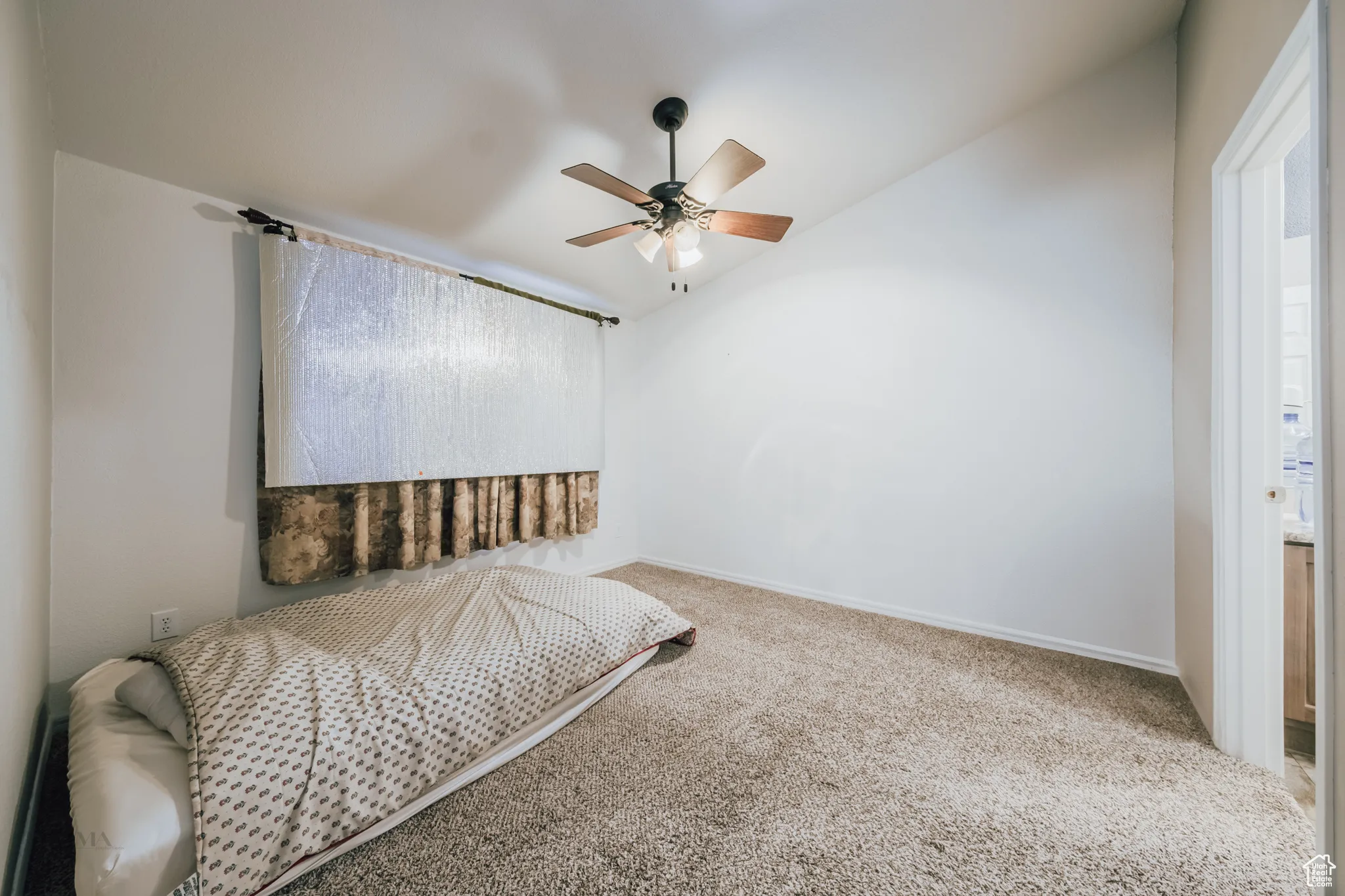 Bedroom with carpet, a ceiling fan, and vaulted ceiling