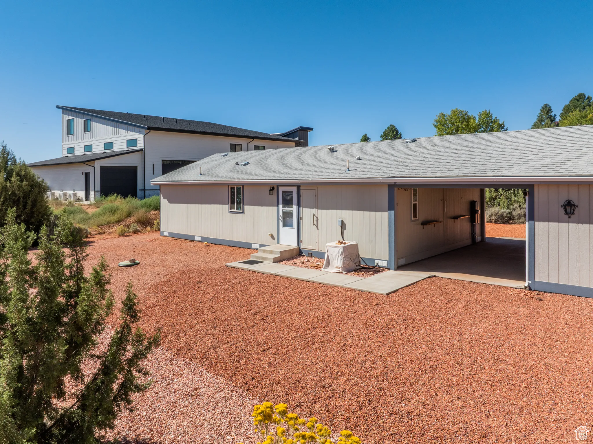 Rear view of property with roof with shingles and an attached carport