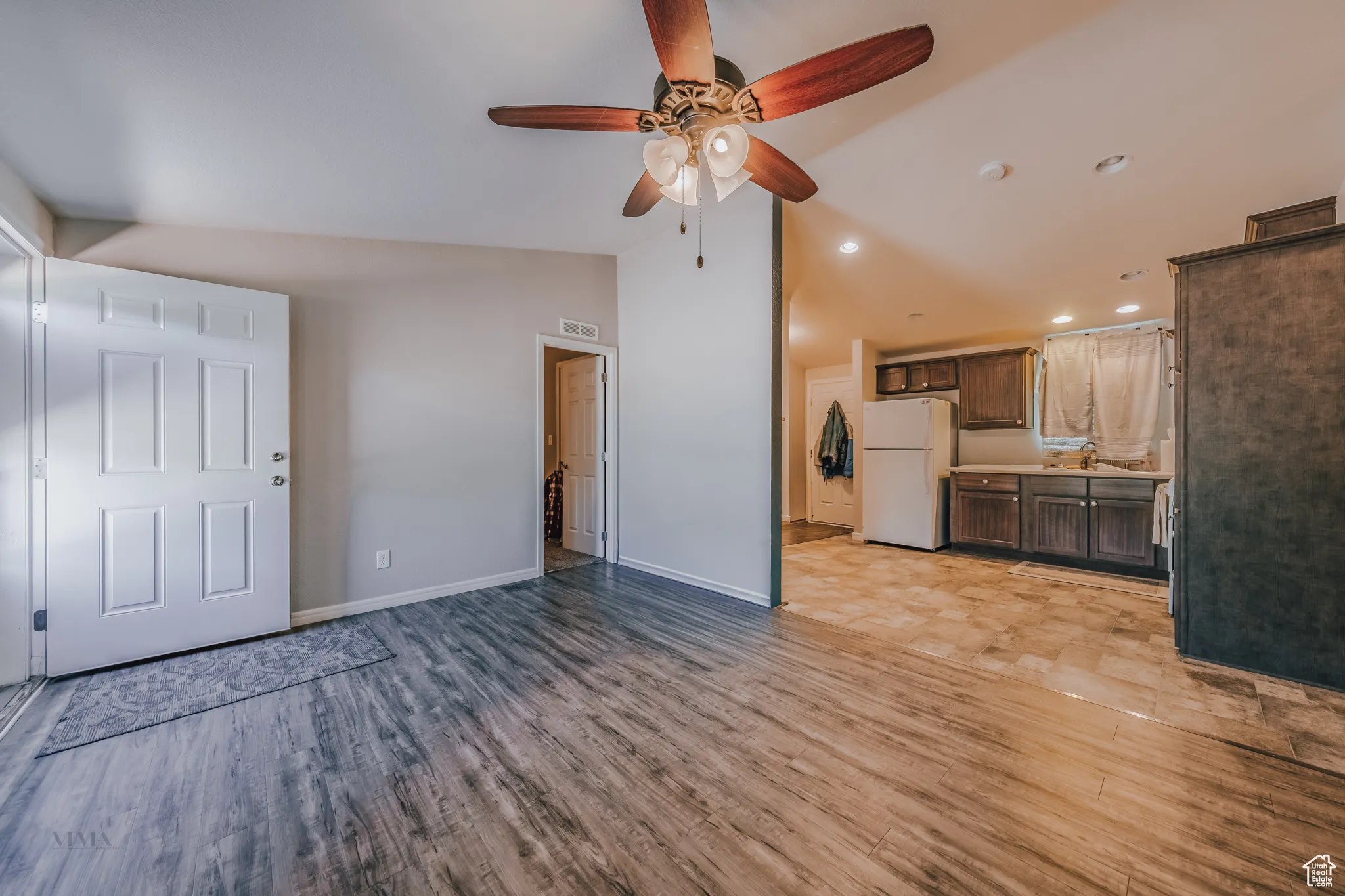 Unfurnished living room featuring light wood-type flooring, lofted ceiling, ceiling fan, and recessed lighting