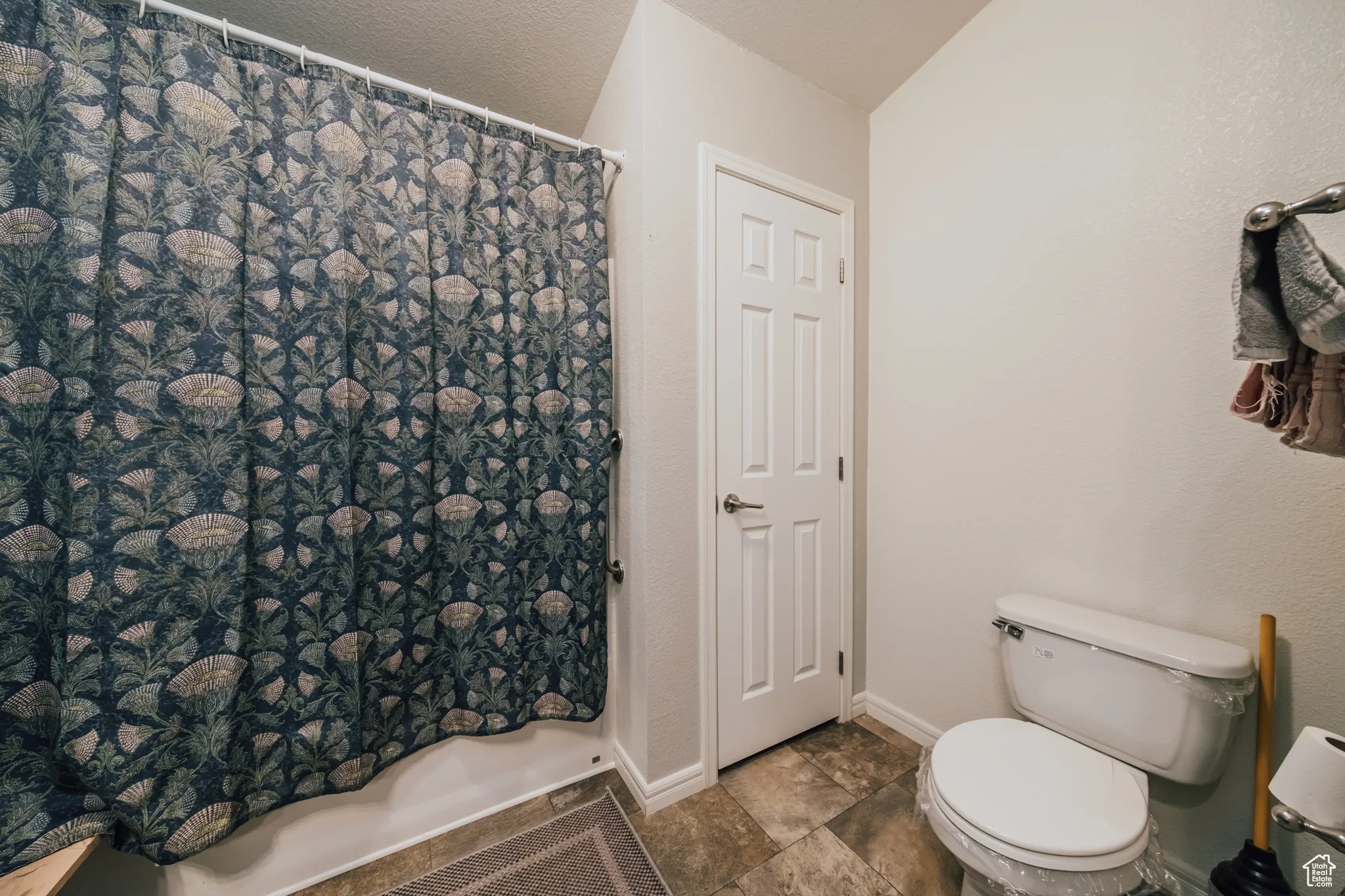 Bathroom with toilet and a shower with curtain