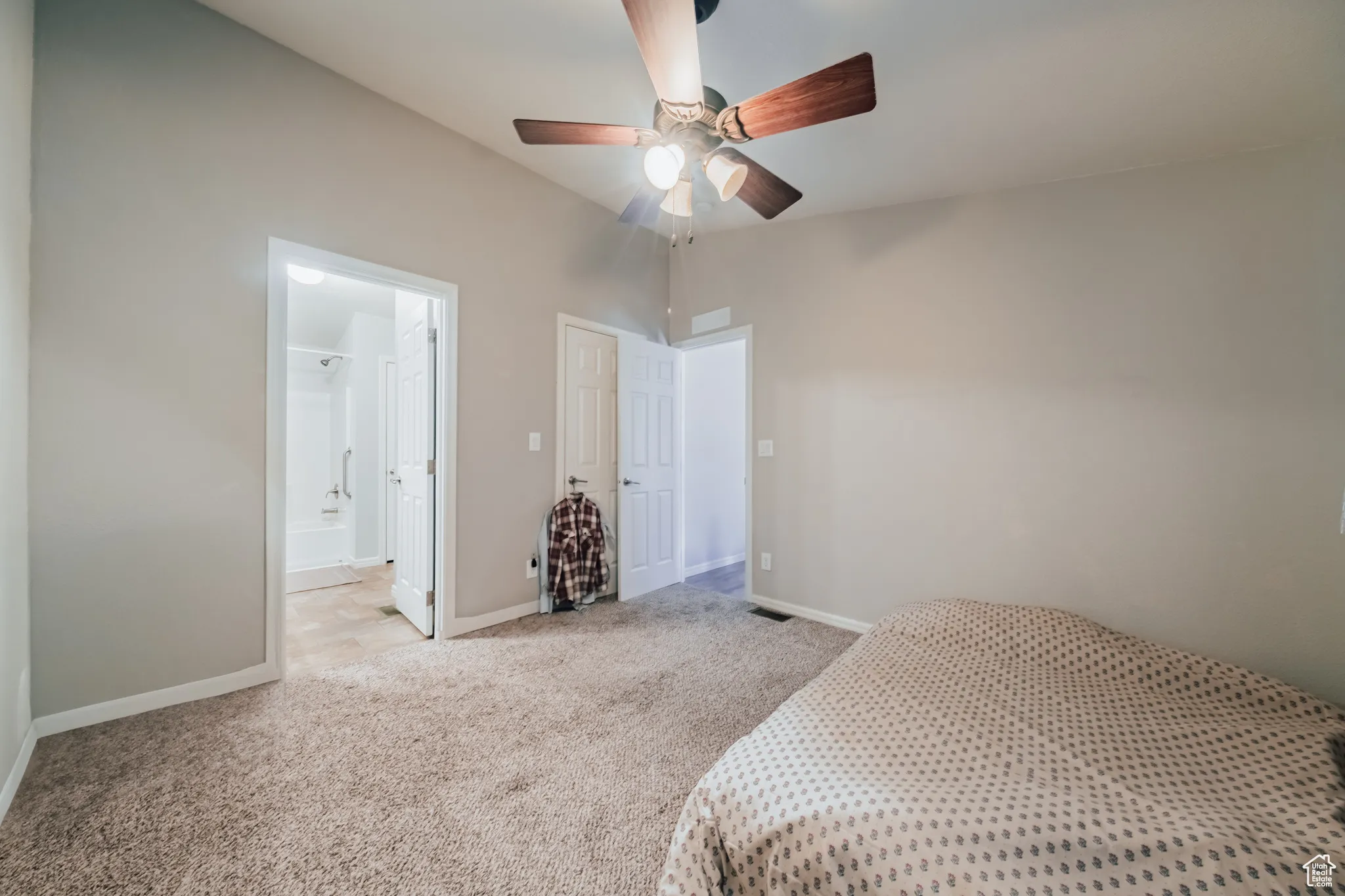 Bedroom featuring carpet, vaulted ceiling, ceiling fan, and connected bathroom