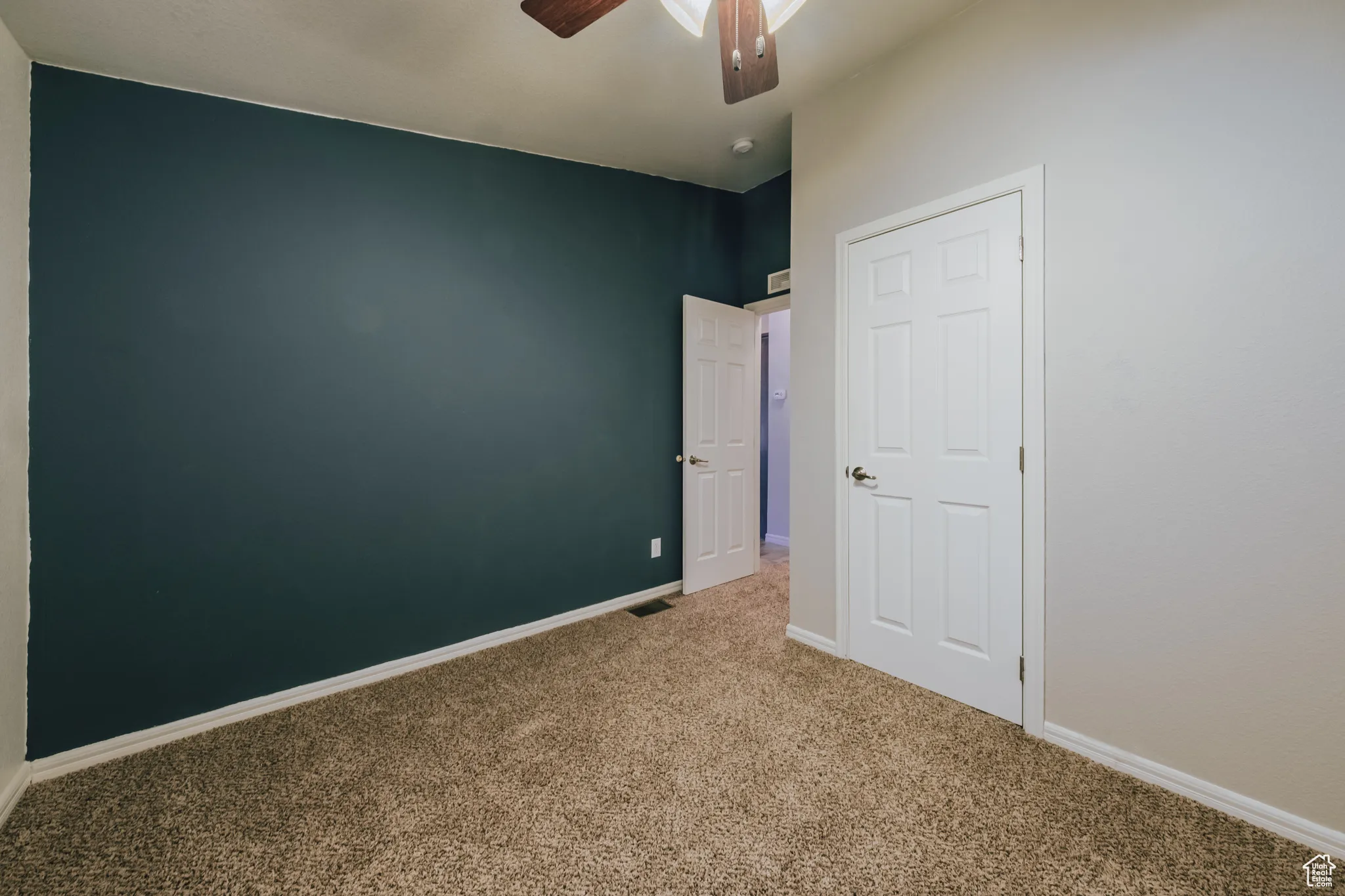Unfurnished bedroom with carpet floors and a ceiling fan