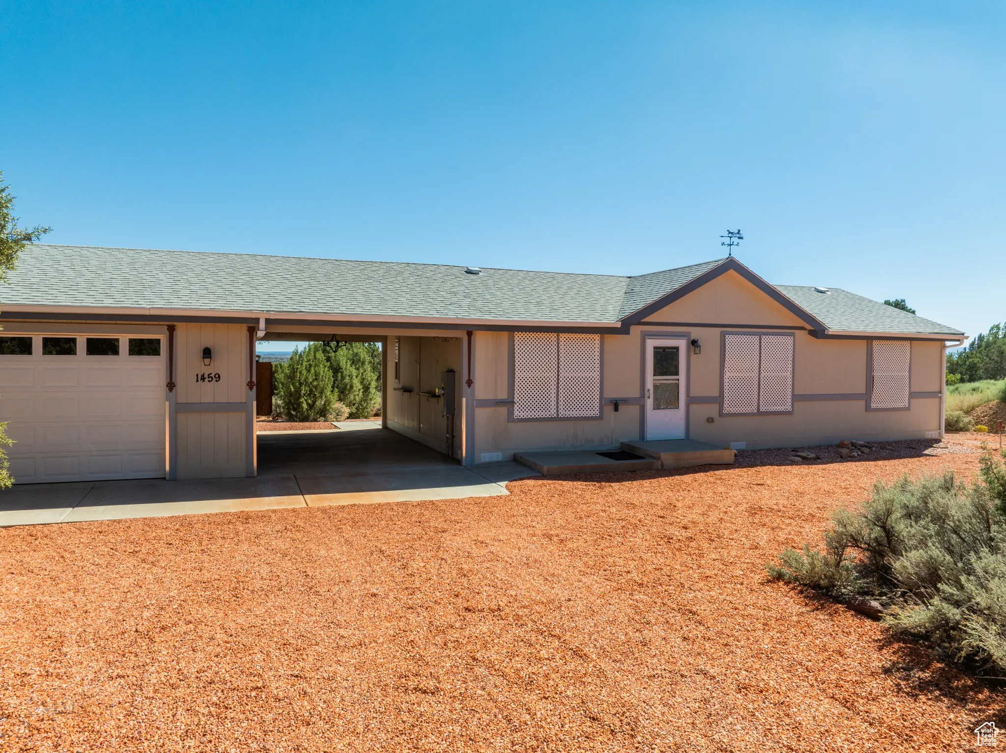 Ranch-style home with a shingled roof and a garage