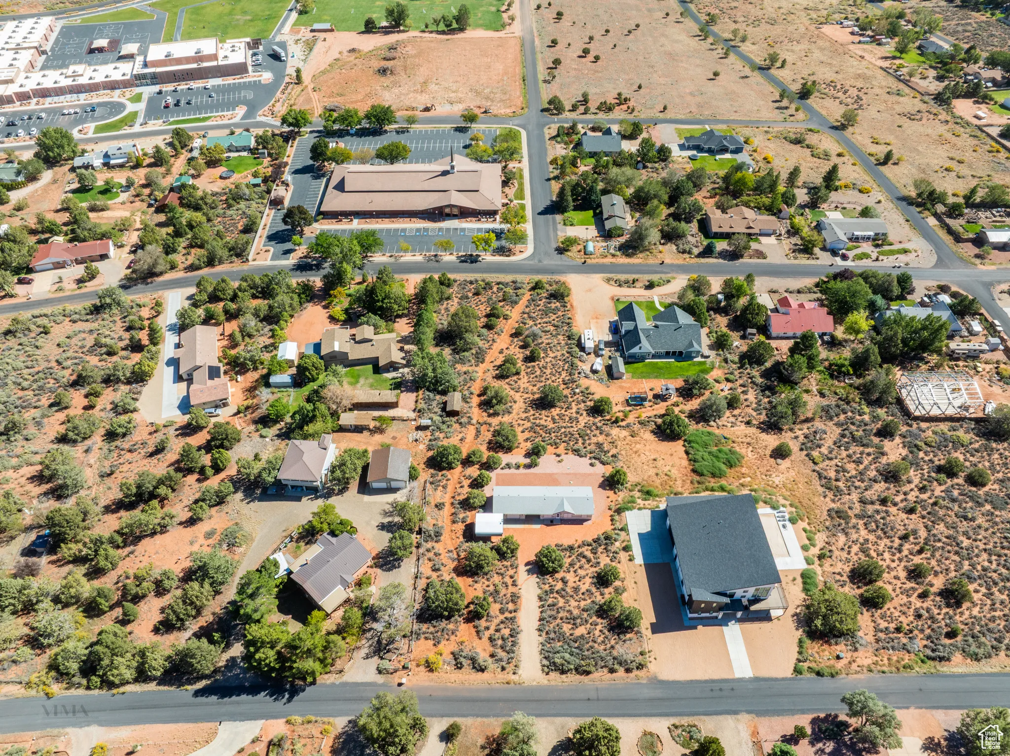 Aerial view of property and surrounding area featuring nearby suburban area