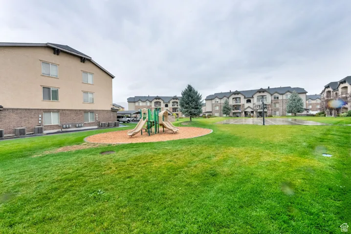 Communal playground with a yard and a residential view