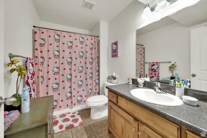 Bathroom with vanity, light tile patterned flooring, and shower / tub combo
