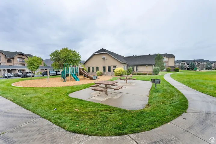 Community playground with a lawn, a residential view, and a patio