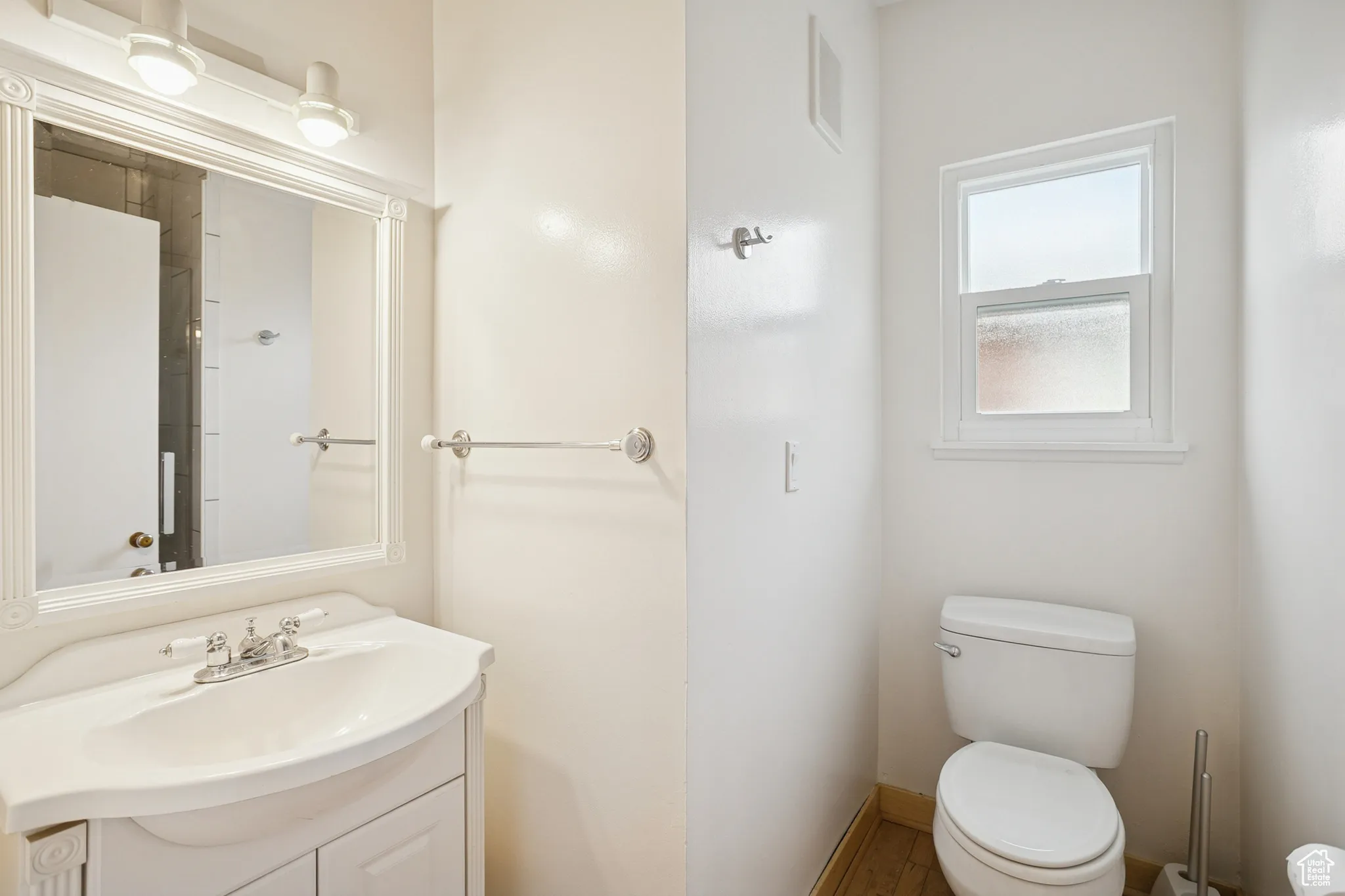 Half bath with vanity and wood finished floors